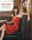 Alyson posant dans une robe rouge assise sur un canap de bar